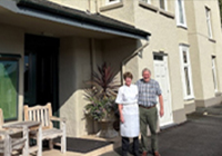 2 pobl sefyll tu allan i gwesty